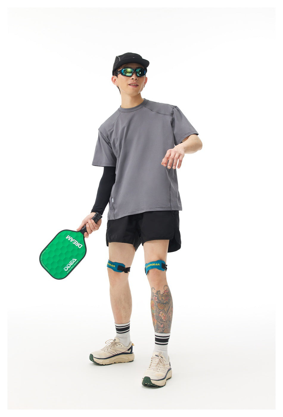 Full-length model wearing a gray short-sleeve T-shirt and black shorts against a white background.