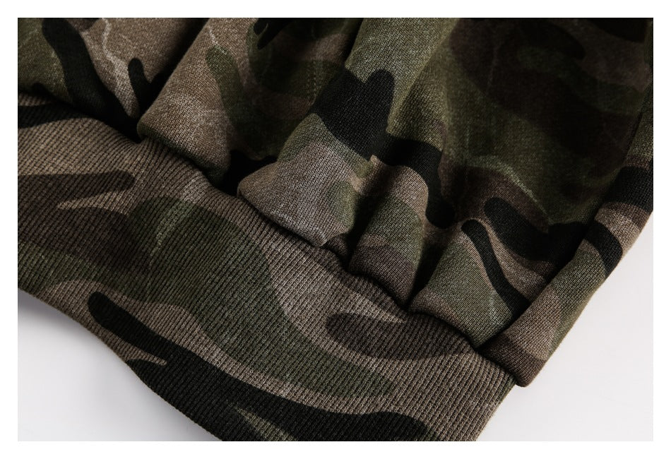 Close-up of the camouflage hoodie's ribbed waistband and gathered fabric.