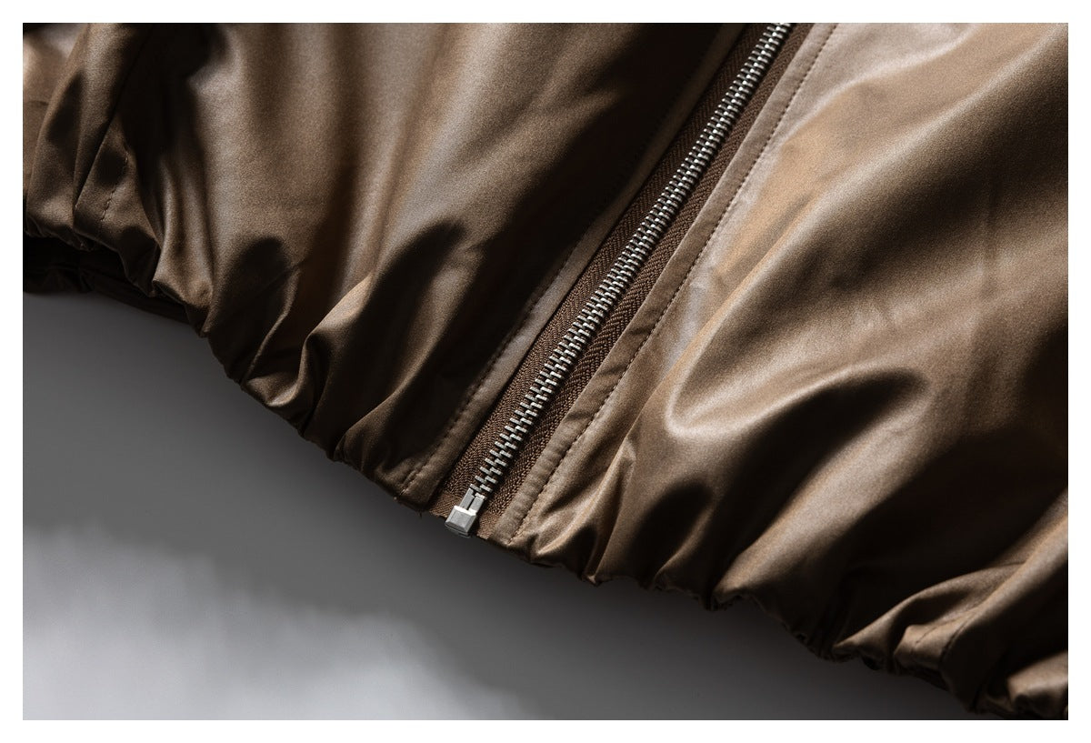Close-up of the brown jacket's metal zipper and gathered elastic hem.