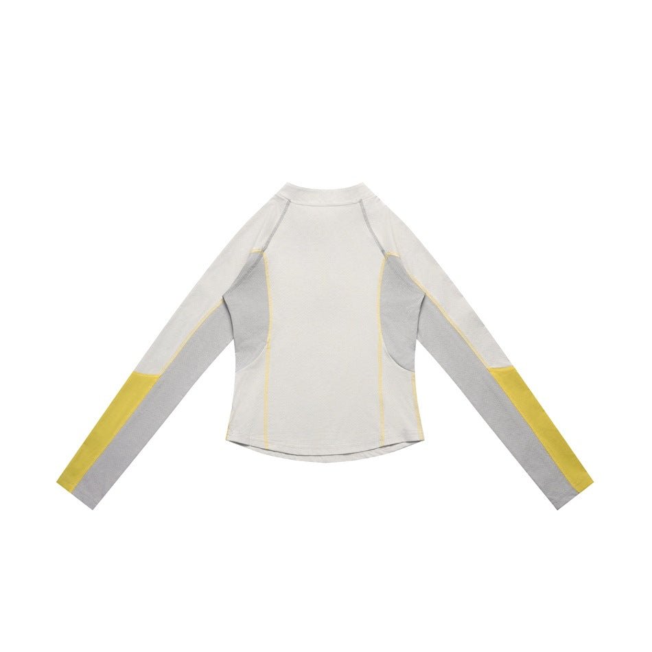 Back view of a pale top with gray side panels and sleeves, yellow lower-sleeve blocks, and contrast seams.