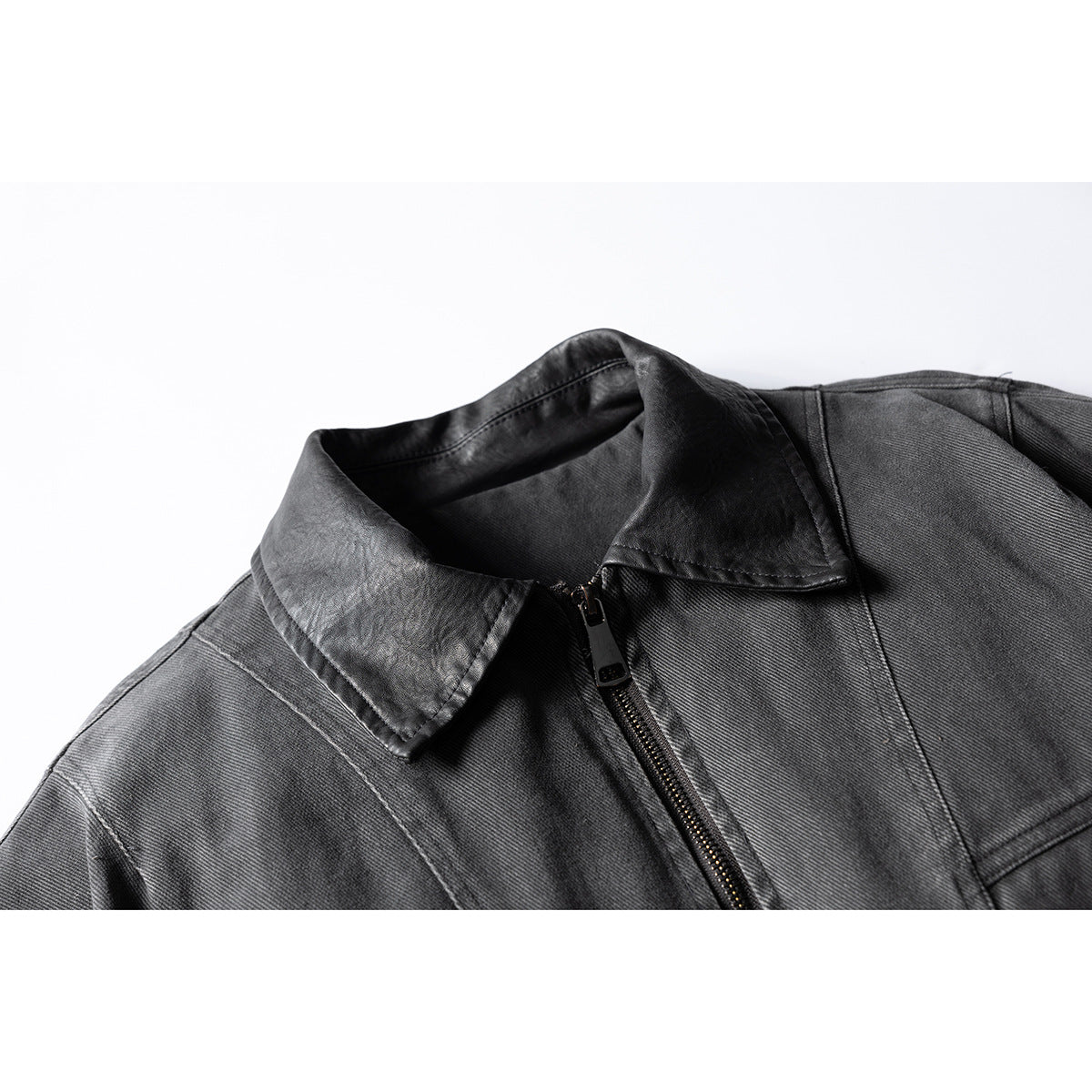 Close-up of the dark gray jacket's pointed collar and front zipper.
