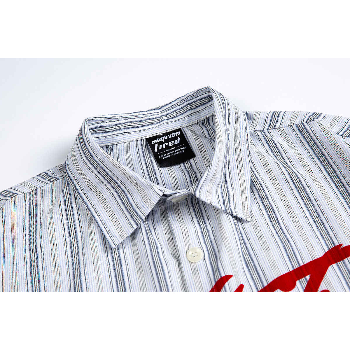 Close-up of a white short-sleeve shirt with fine blue-gray stripes, pointed collar, and partial red chest print.