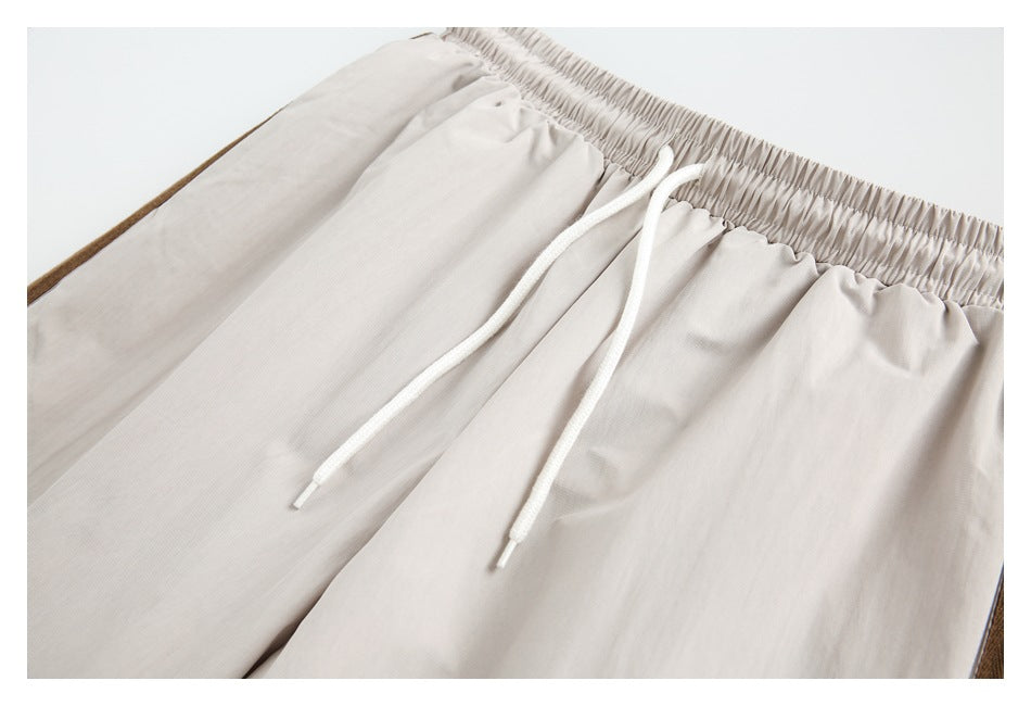 Close-up of beige pants with an elastic waistband and long white drawstrings.