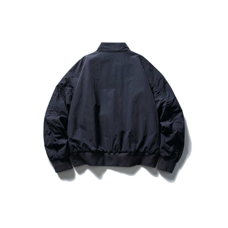 Back view of navy jacket flat lay showing plain back panel, ruched sleeves and ribbed hem and cuffs