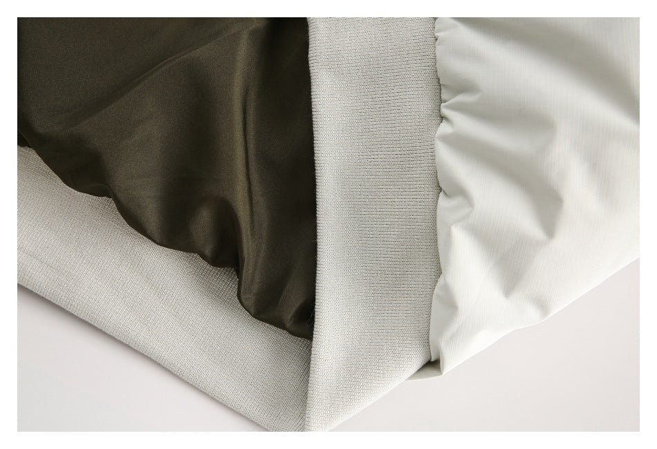 Close-up of the jacket's dark inner lining, white shell, and ribbed hem.