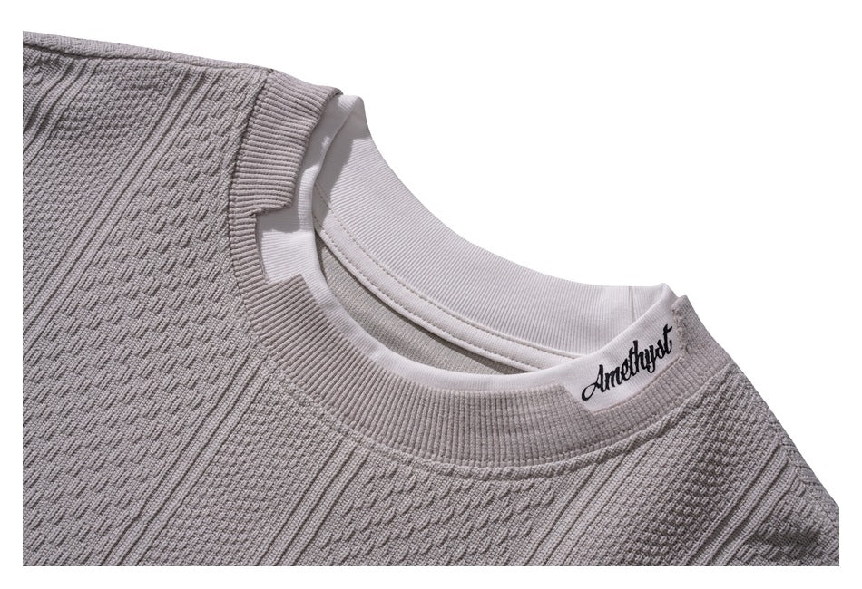 Close-up of the sweatshirt's ribbed crew neck and textured knit, with a small script label near the neckline.