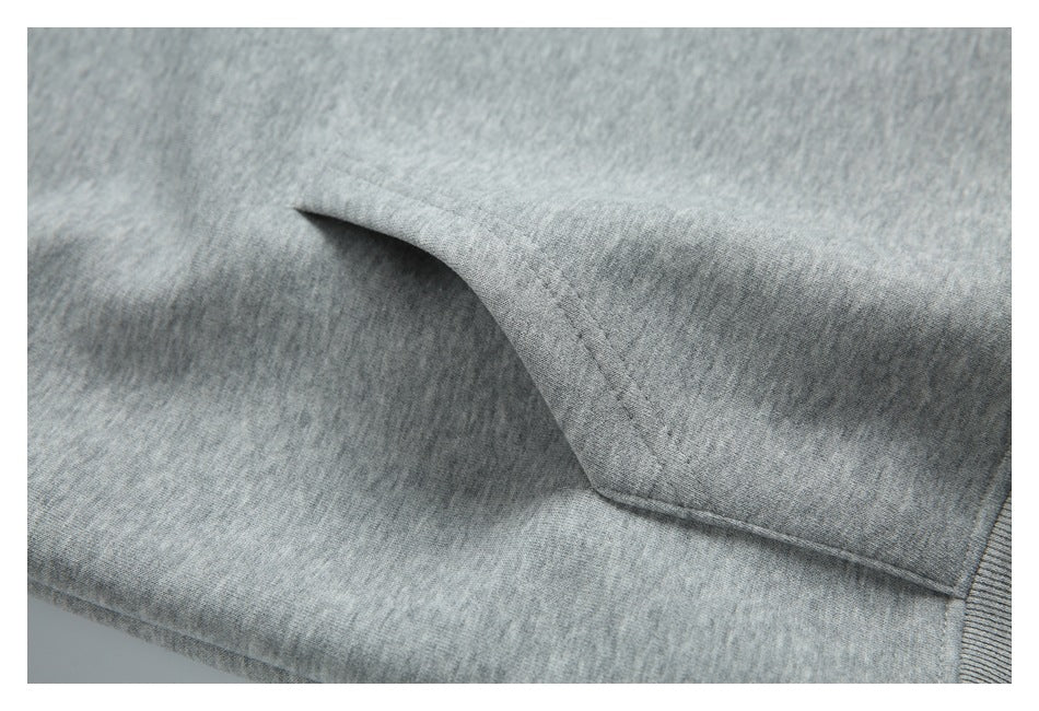 Close-up of the heather gray hoodie’s kangaroo pocket opening and stitching.