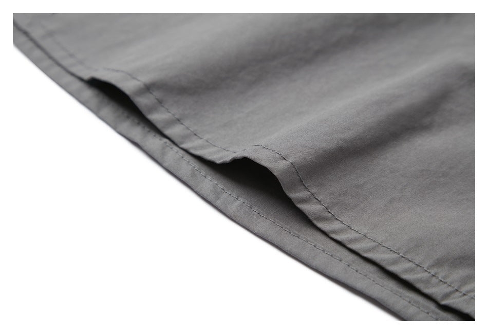 Close-up of a gray garment hem with double stitching and a folded edge.