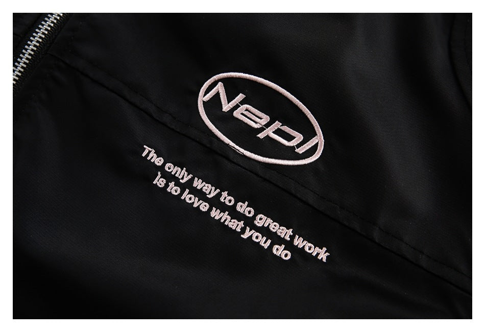 Close-up of pale pink embroidered oval lettering and the slogan “The only way to do great work is to love what you do” on