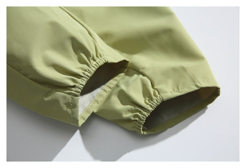 Close-up of gathered elastic cuffs on the pale olive jacket sleeves.