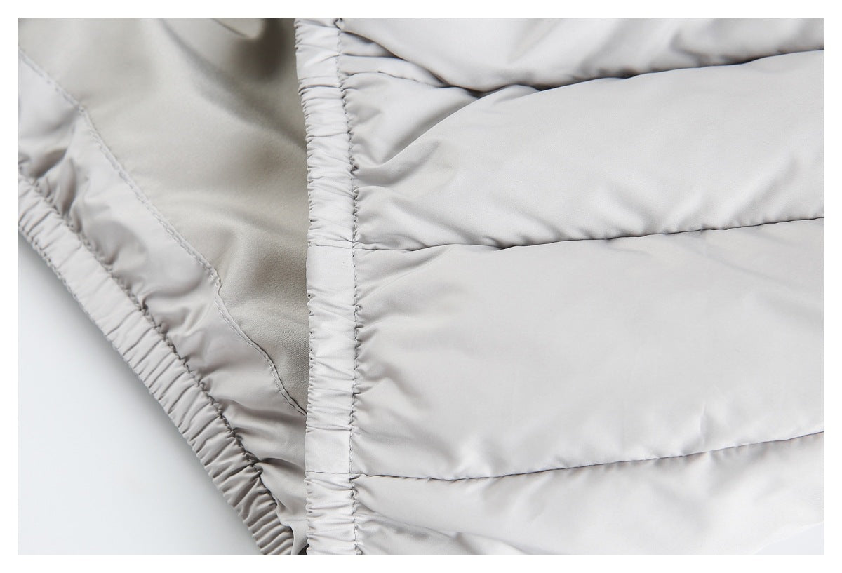 Close-up of a light gray padded garment with horizontal quilted channels and a gathered elastic edge.