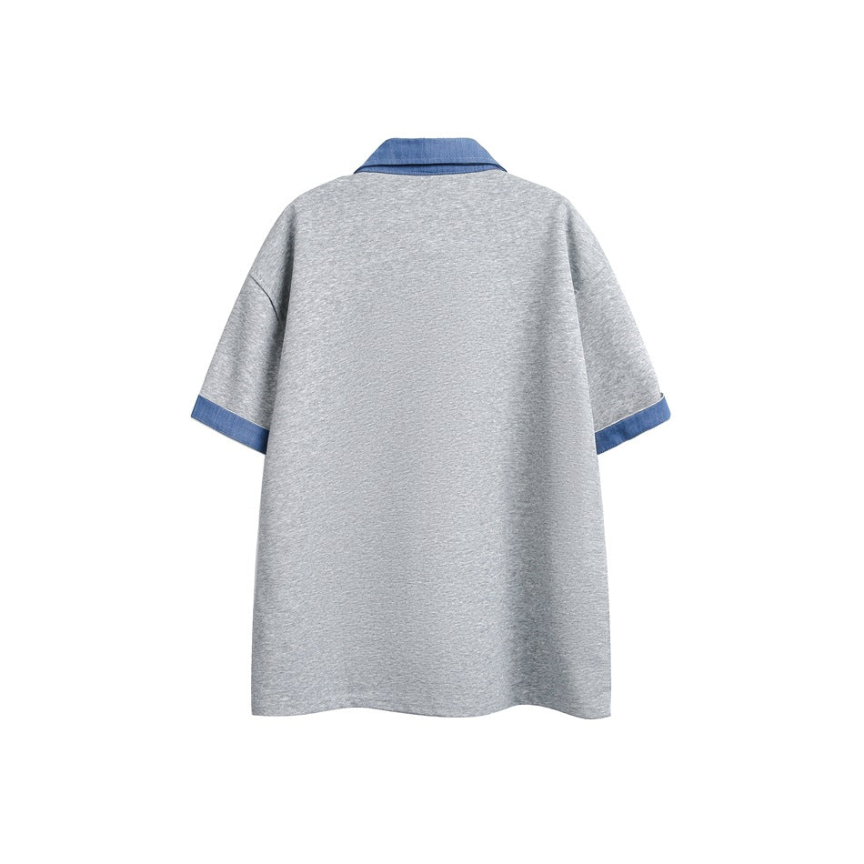 Back view of a gray short-sleeve top with a blue collar and blue sleeve cuffs, shown flat against white.