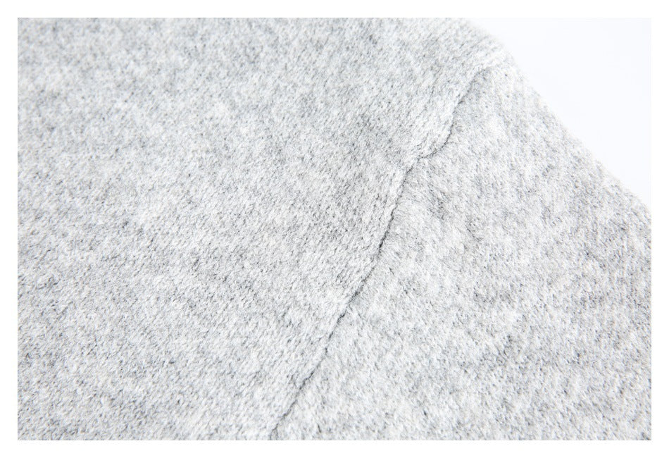 Close-up of a seam across the light gray knit garment.