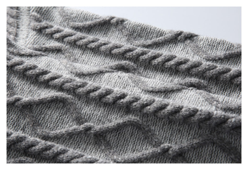 Close-up of gray knit fabric with raised cable-pattern bands.