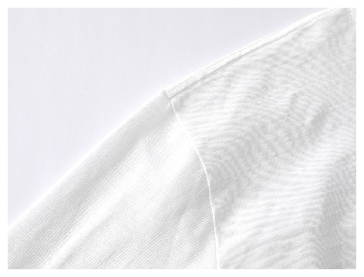 Close-up of a white T-shirt shoulder seam and short sleeve.