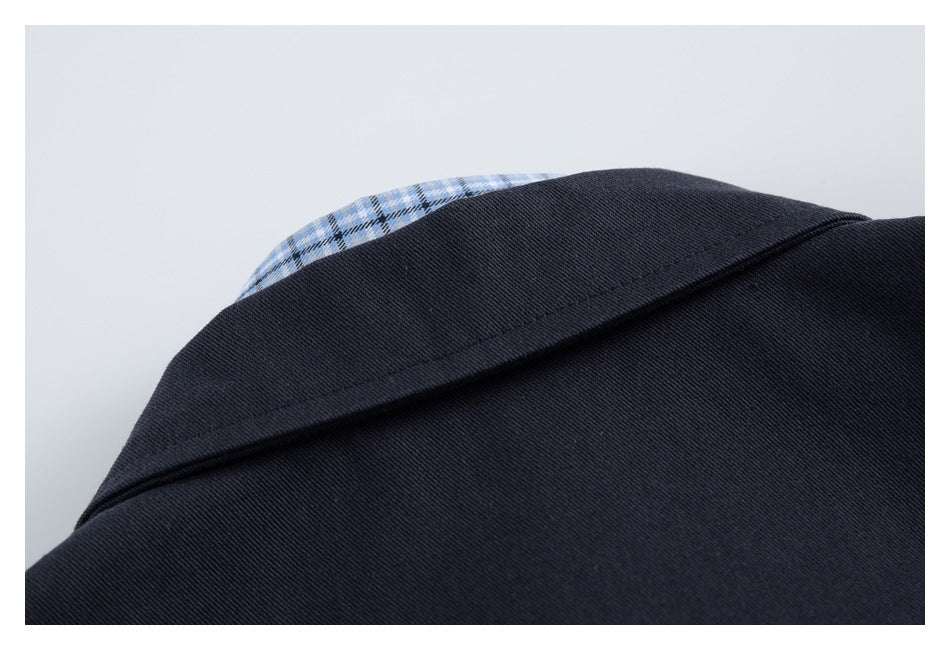 Close-up of a dark navy collar with blue plaid fabric peeking from beneath it.