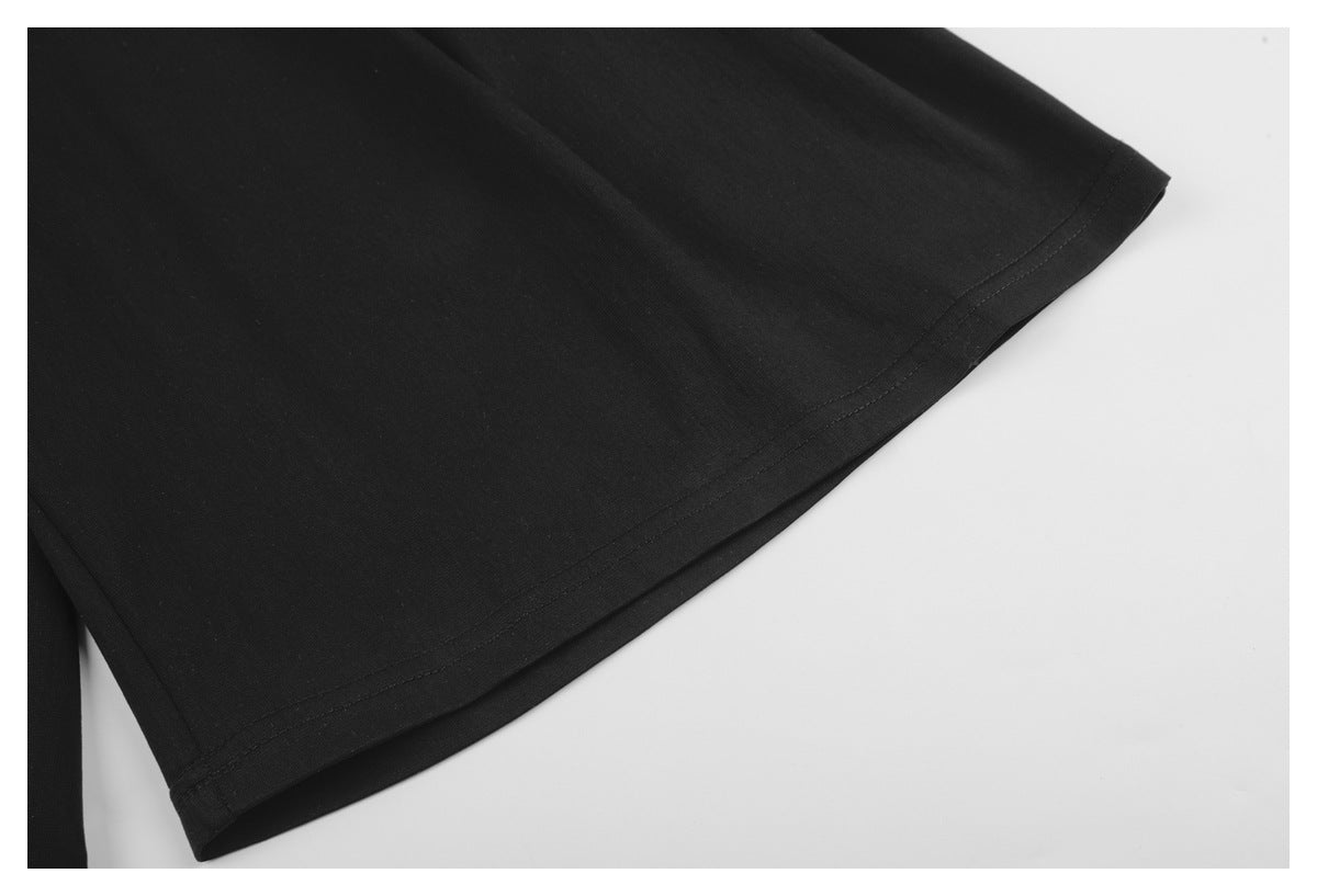 Close-up of the double-stitched hem on black trousers.