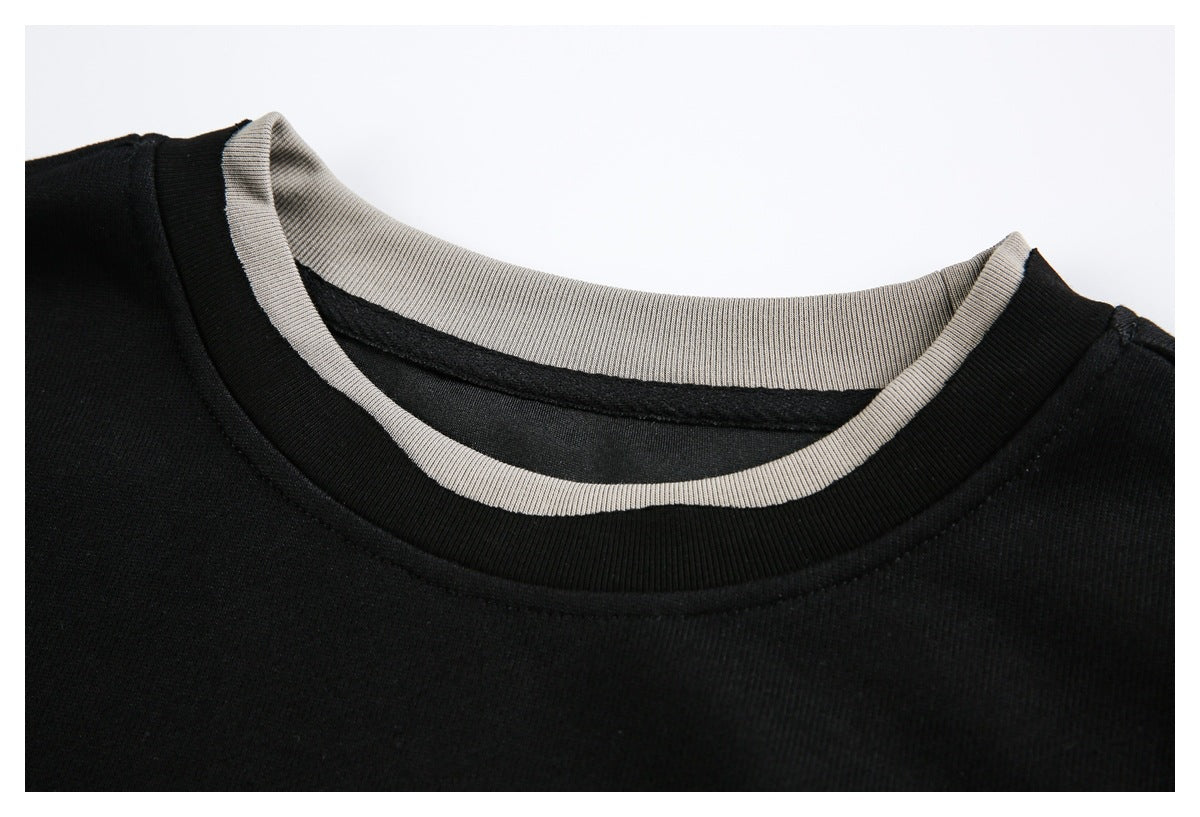 Close-up of a black crewneck sweatshirt with light gray ribbed inner collar trim.