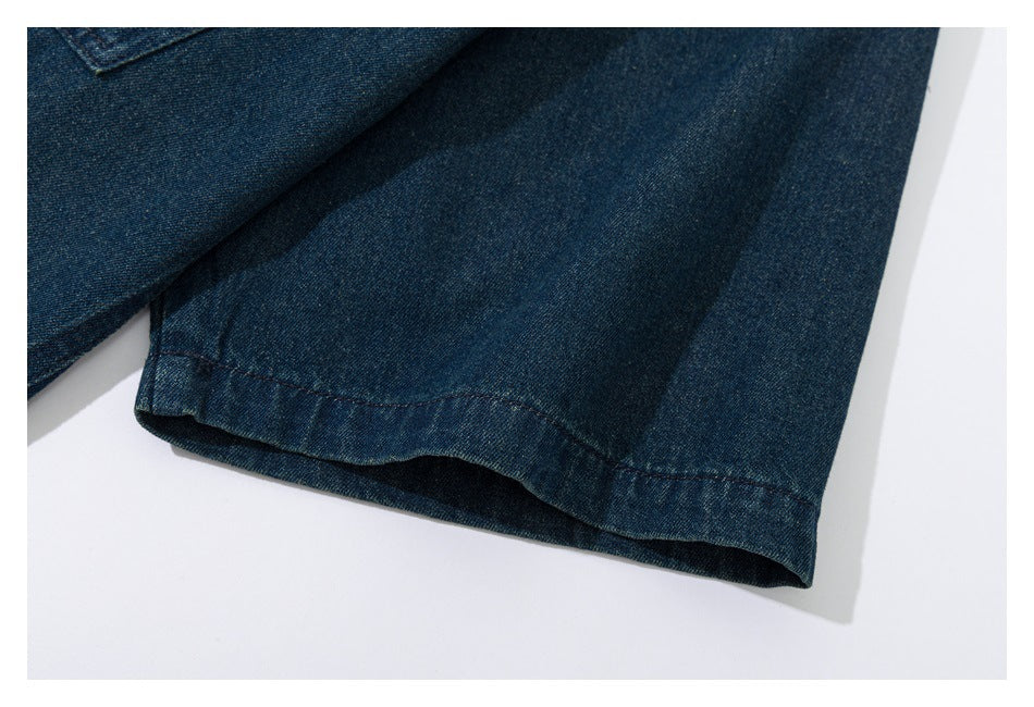 Close-up of a dark blue denim sleeve cuff with a curved stitched edge.