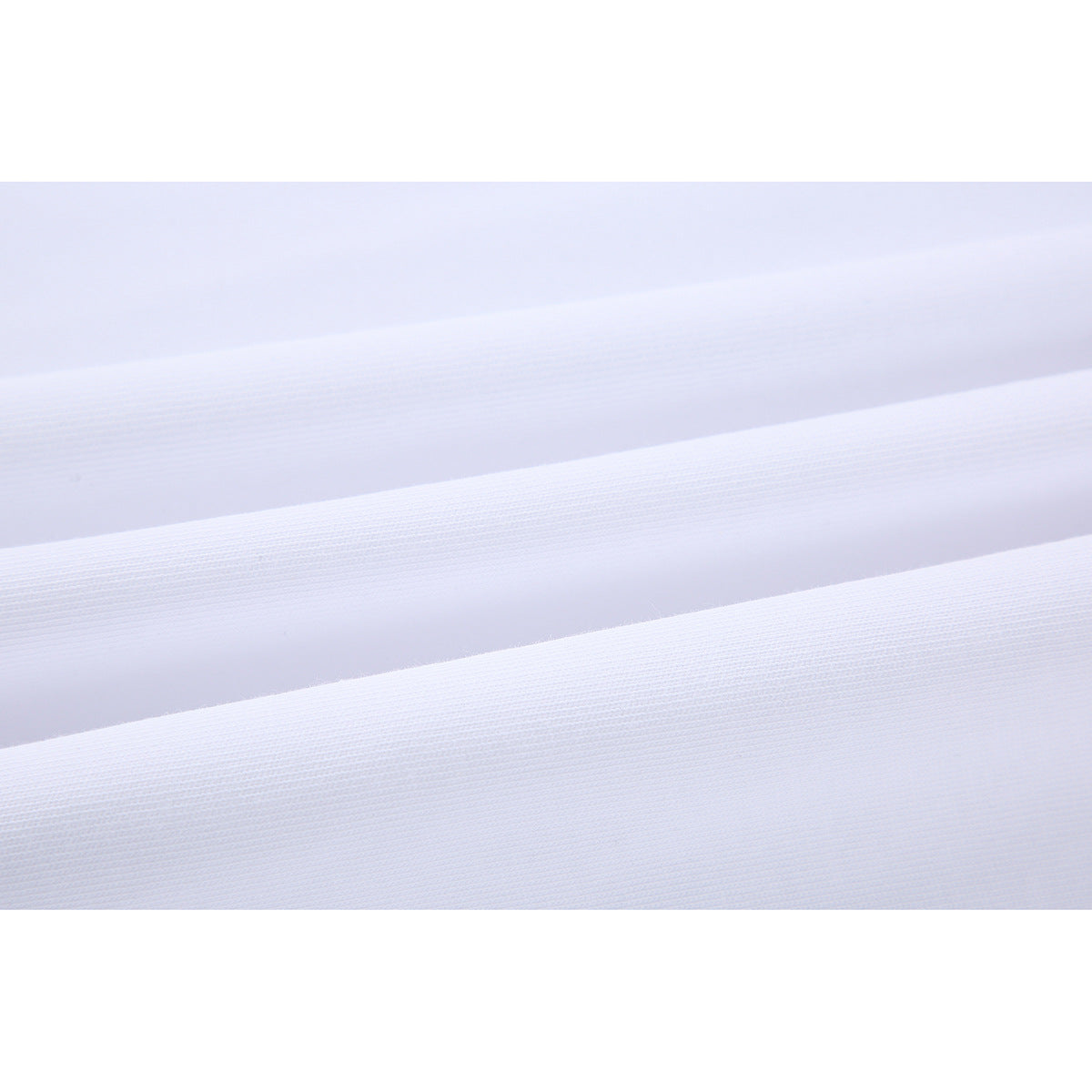 Extreme close-up of white fabric showing its fine knit texture and several parallel folds.