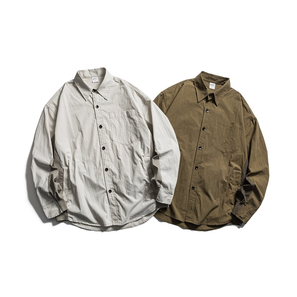 Two long-sleeved button-up shirts with chest pockets, shown from the front in light gray and olive.