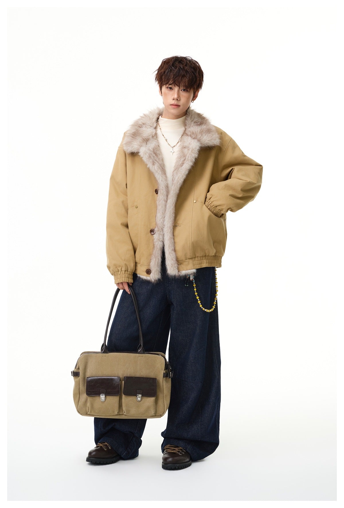 Full-length model wearing a tan jacket with pale fur trim and dark wide-leg jeans, carrying a tan shoulder bag.