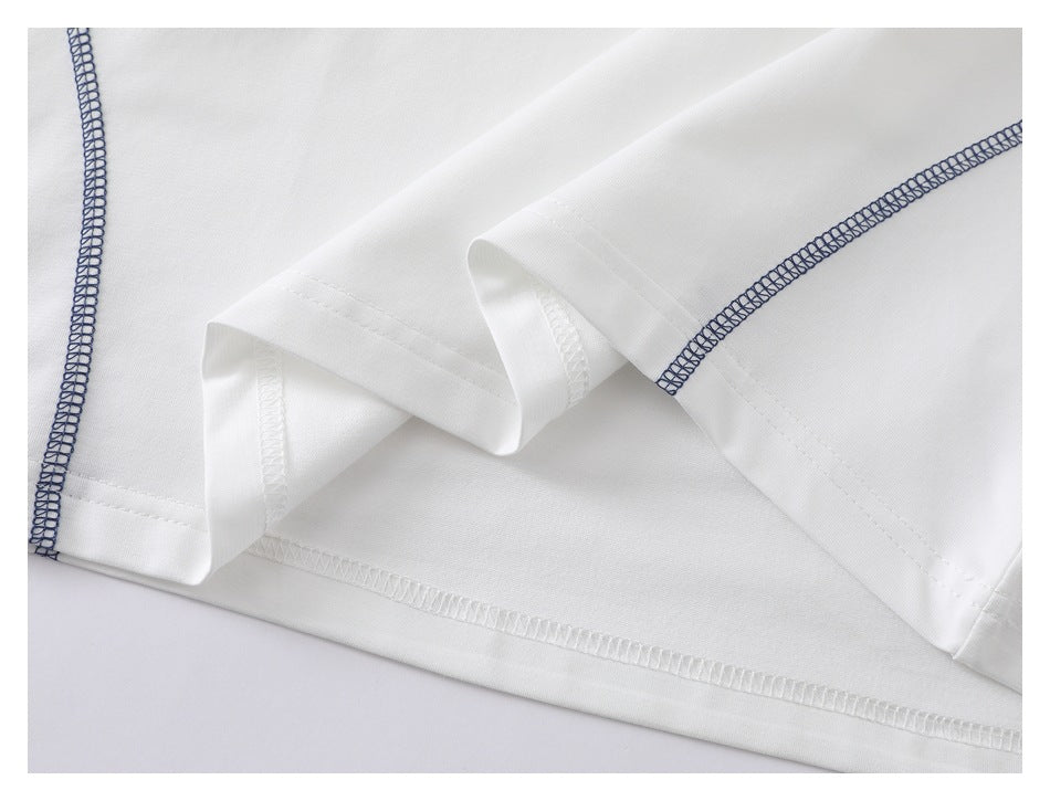 Close-up of the white shirt’s folded hem and stitching, with a navy overlock seam.