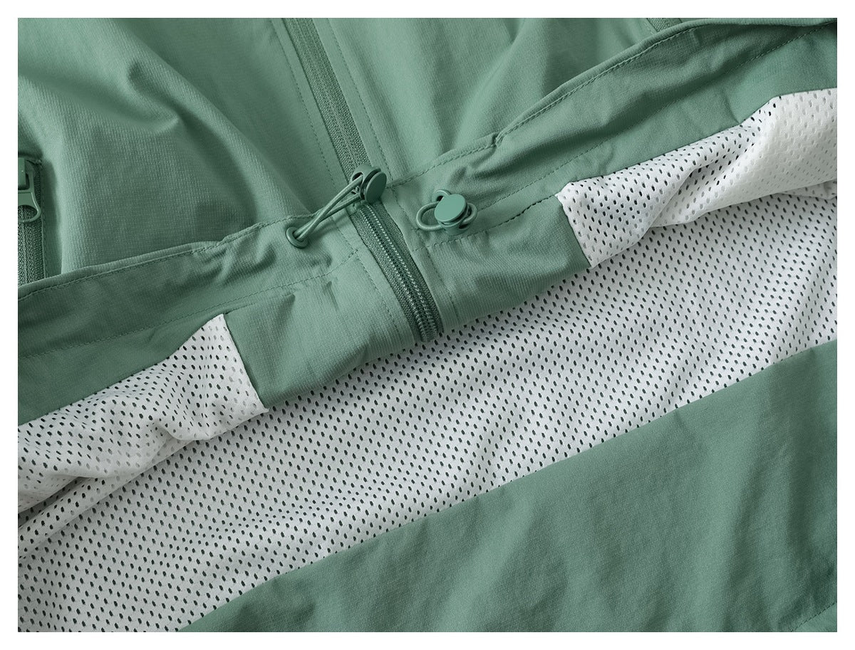 Close-up of the jacket's white mesh lining, green zipper, and adjustable drawcord at the waist.