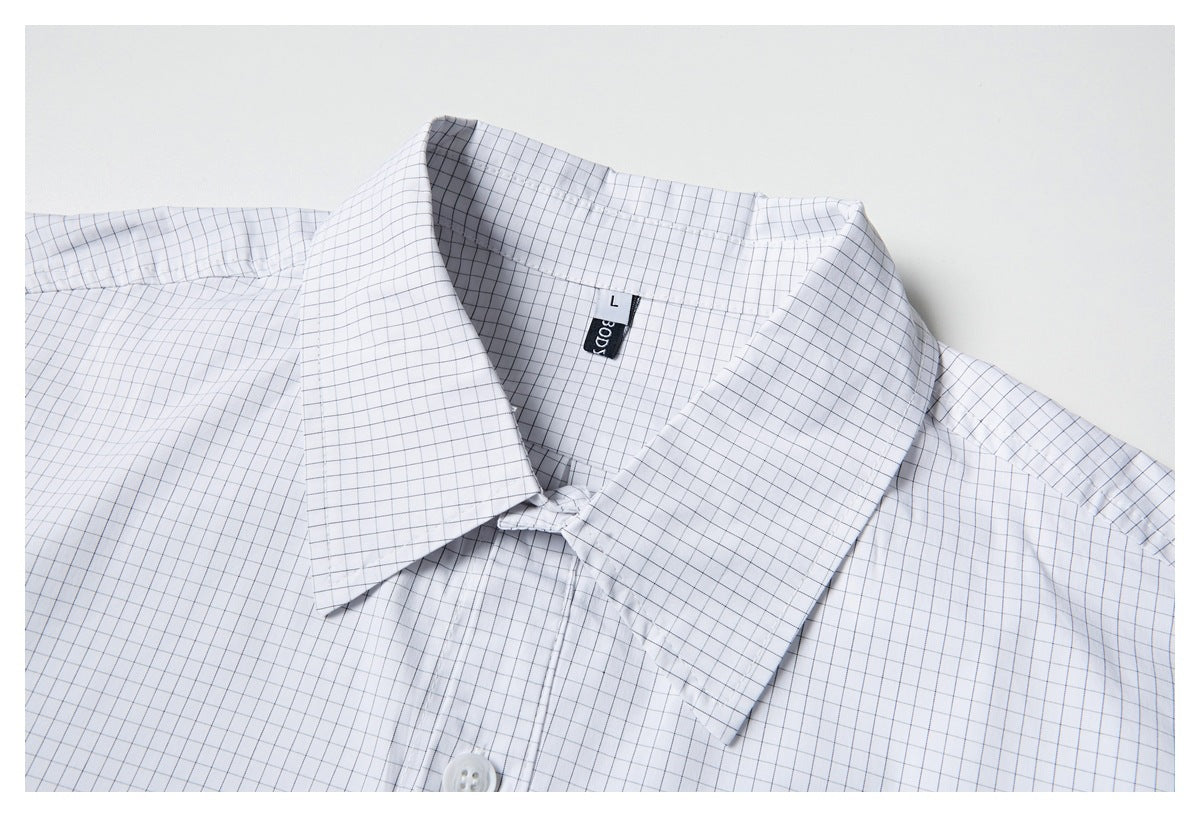 Close-up of a white shirt with a fine gray grid check, pointed collar, and a small black neck label.