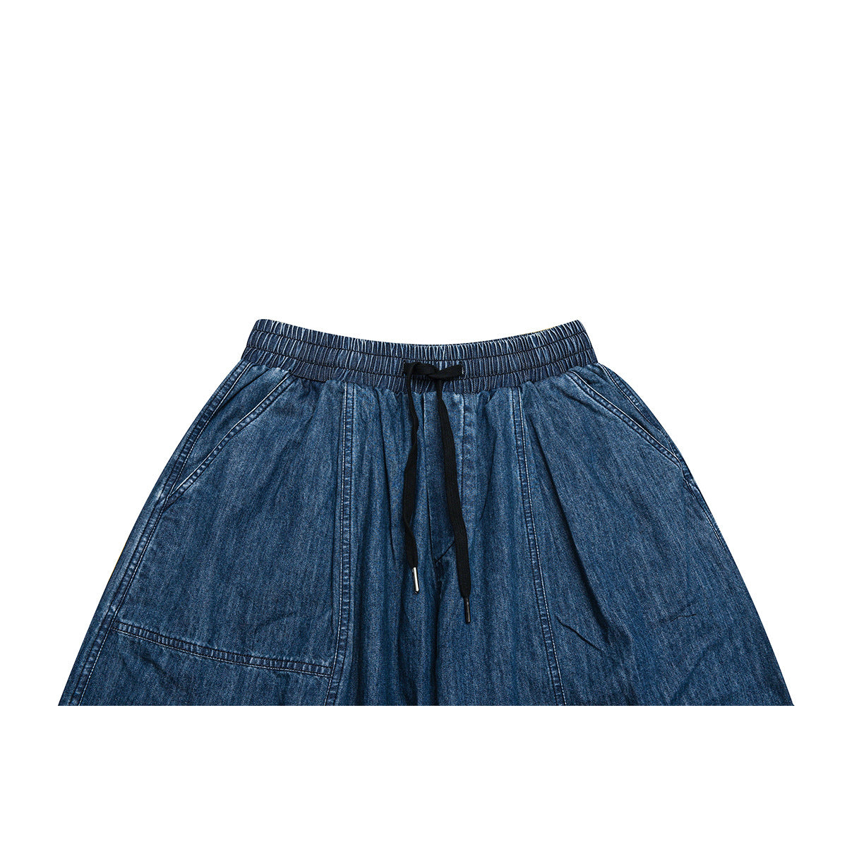 Cropped front view of blue denim trousers with an elastic waistband, black drawstring, and large patch pockets.
