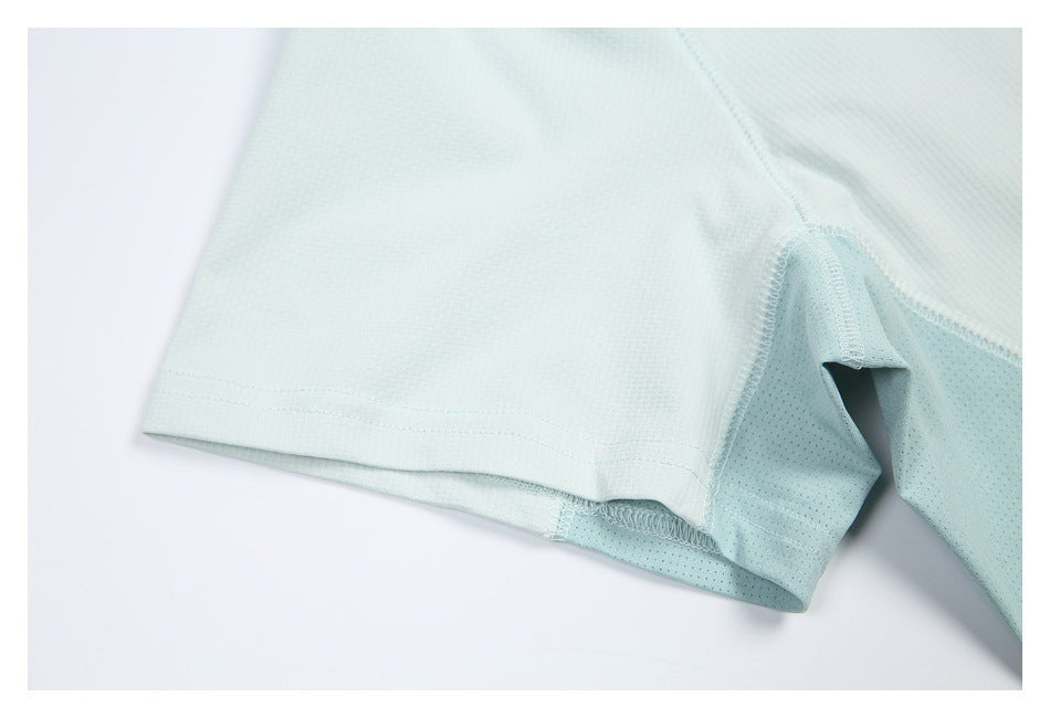 Close-up of a pale mint athletic shirt sleeve hem and perforated mesh underarm panel.