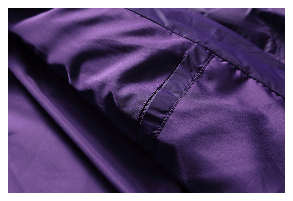 Close-up of stitched seams and shiny purple jacket fabric.