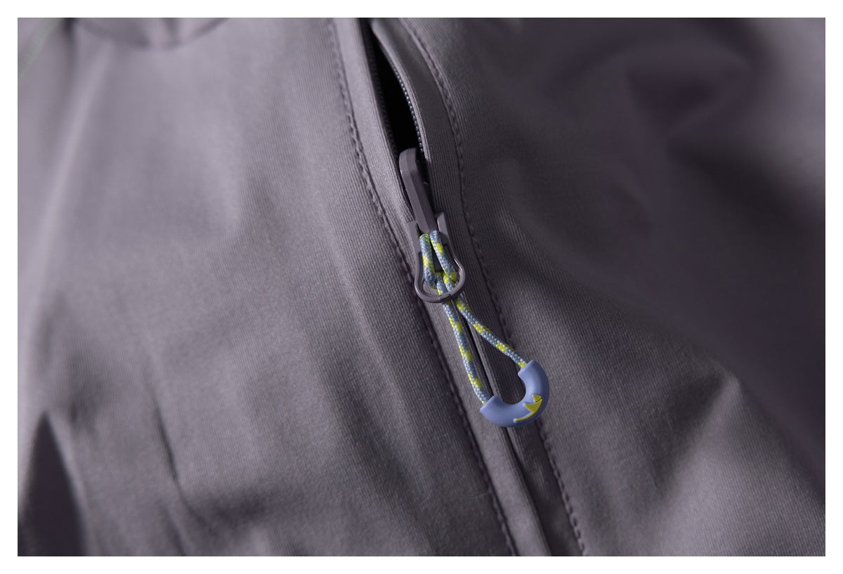 Close-up of a gray jacket zipper with a blue and yellow cord pull.