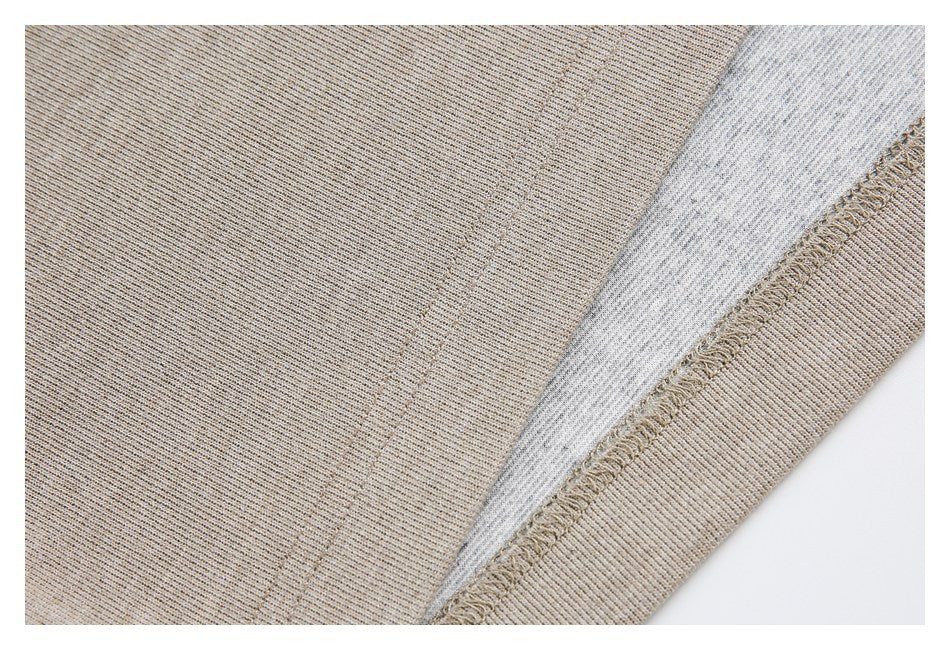 Close-up of taupe and light gray knit fabric layers with a visible overlocked seam.