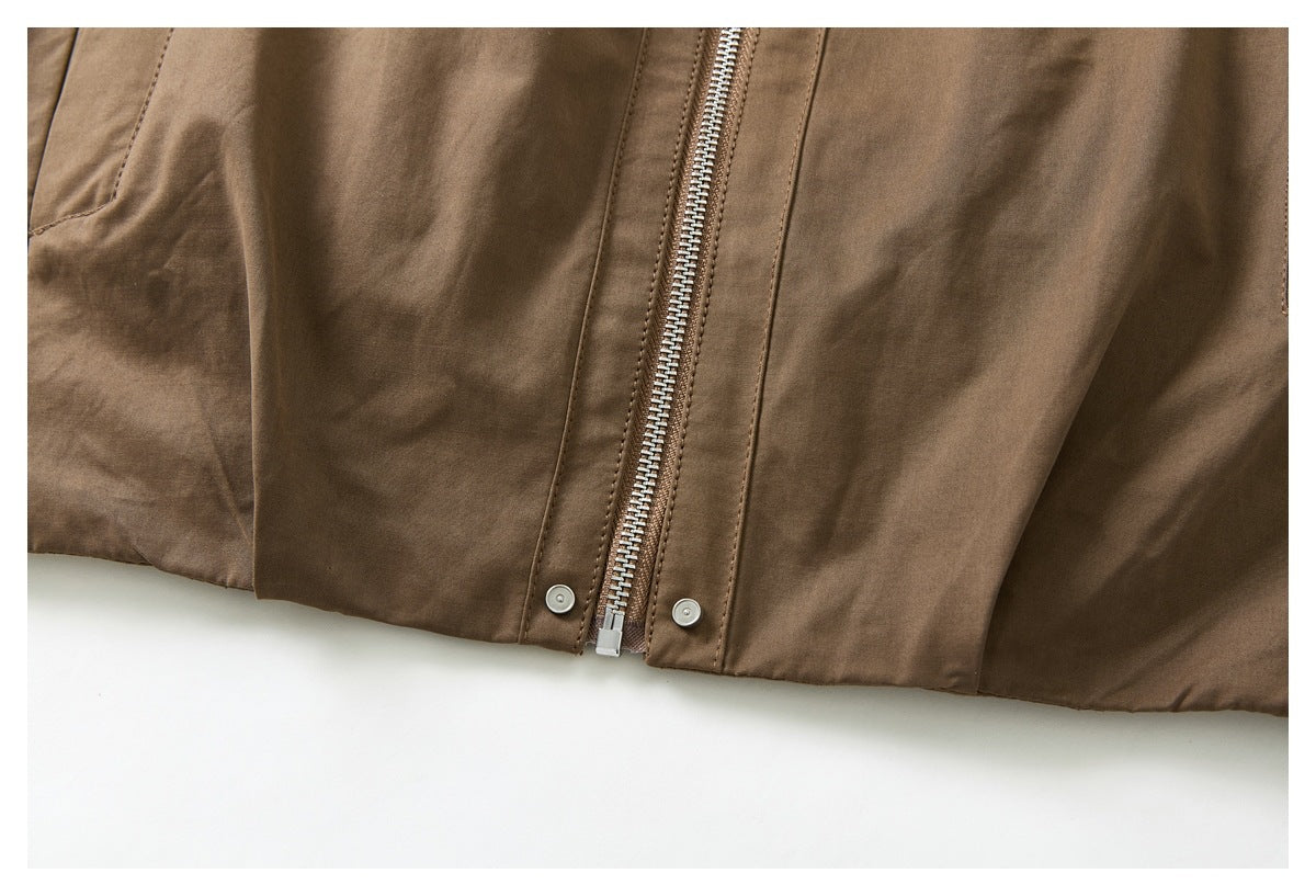Close-up of the lower front of a brown jacket, showing the zipper, snap-button placket, and hem.
