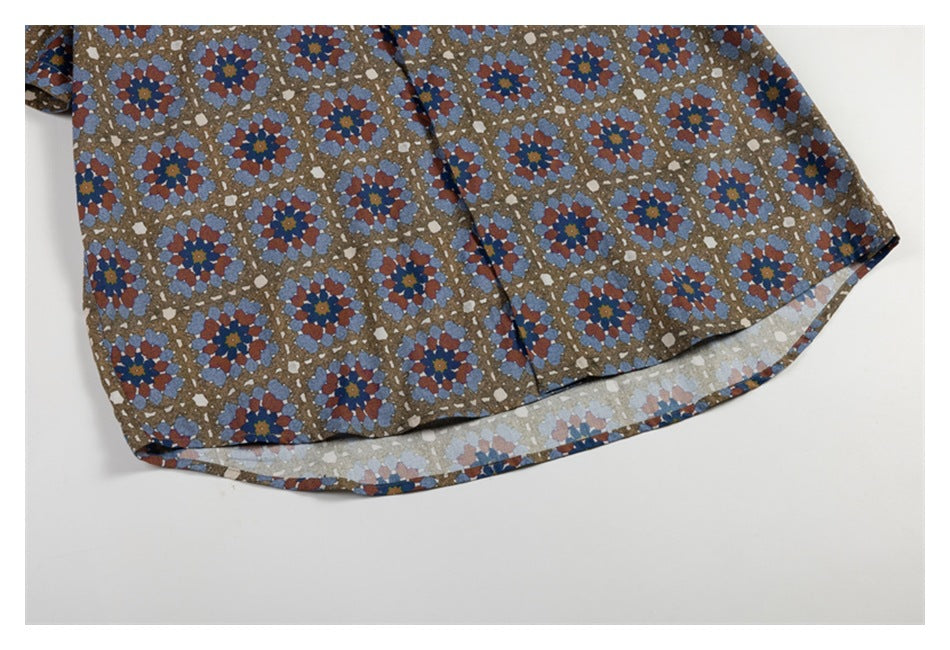 Close-up of a curved shirt hem with a brown, blue, and rust floral geometric print.