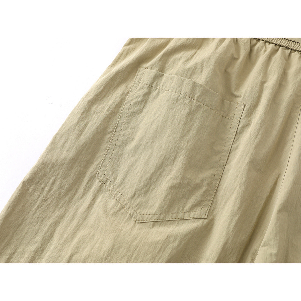 Close-up of a large stitched patch pocket on the khaki shorts.