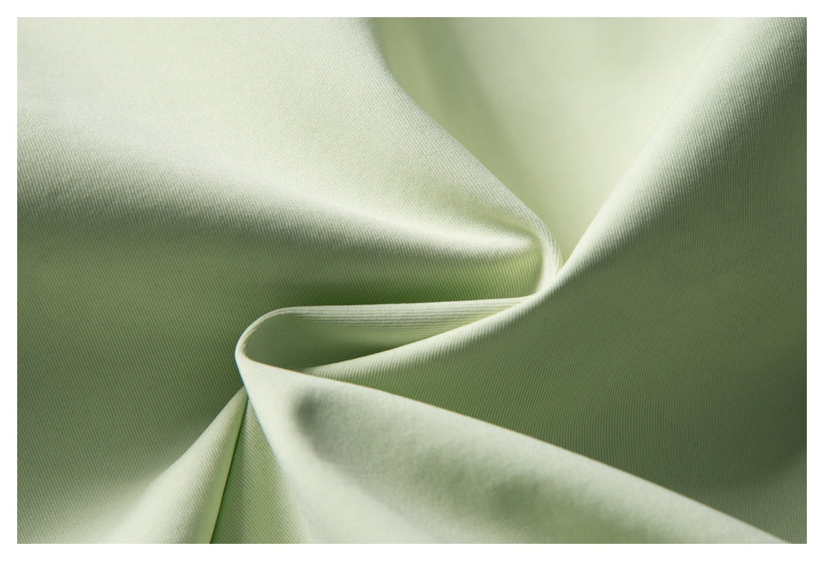 Close-up of pale green fabric draped to show its fine texture.