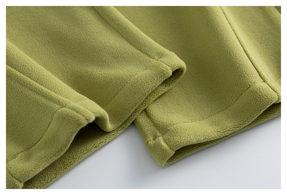 Close-up of the olive-green fleece pants' stitched leg hems.