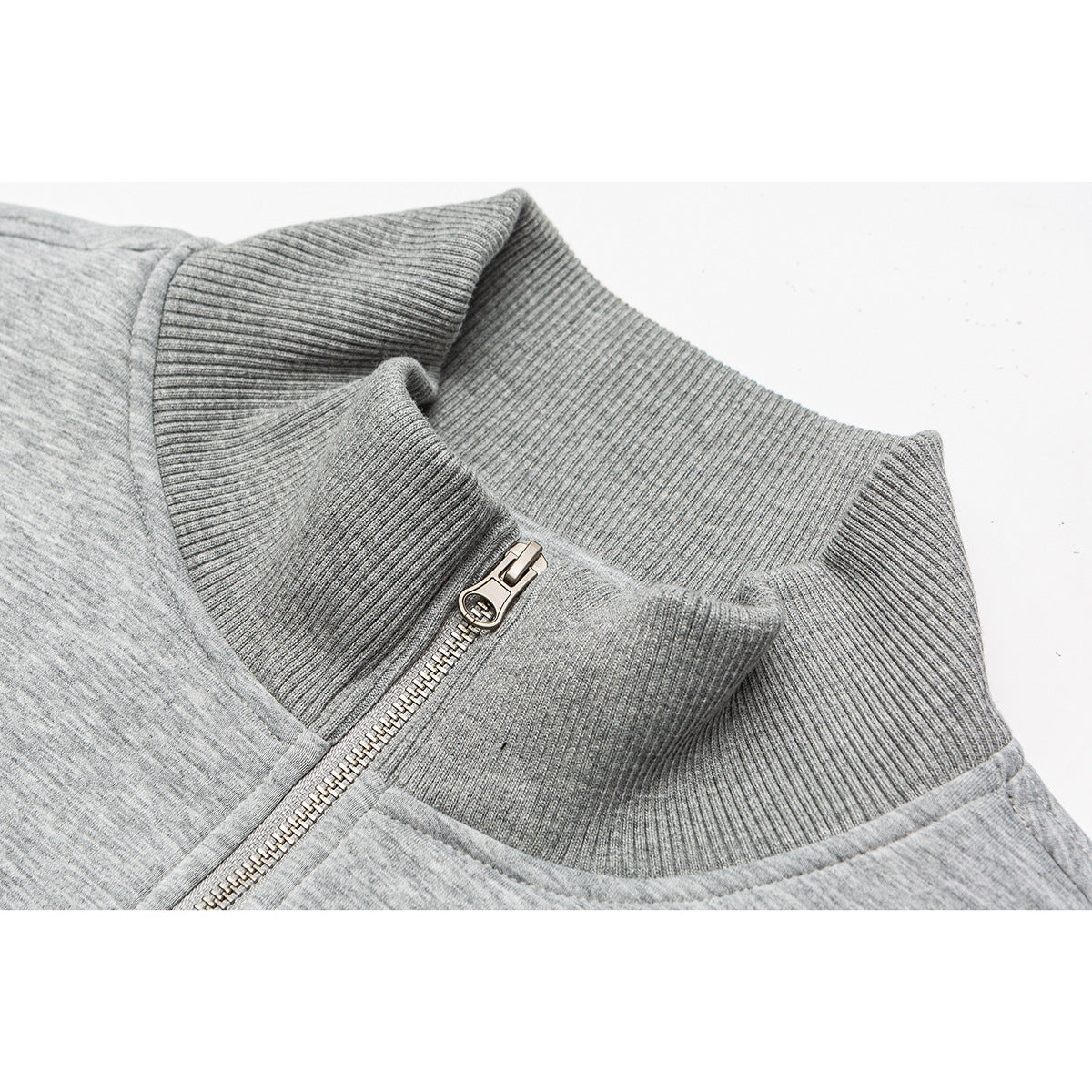 Close-up of a heather gray zip-up jacket's ribbed stand collar and metal zipper.