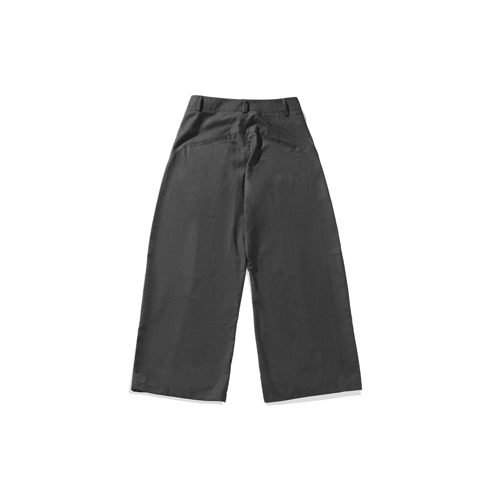 Back view of charcoal gray wide-leg trousers with belt loops and two welt pockets, isolated on white.