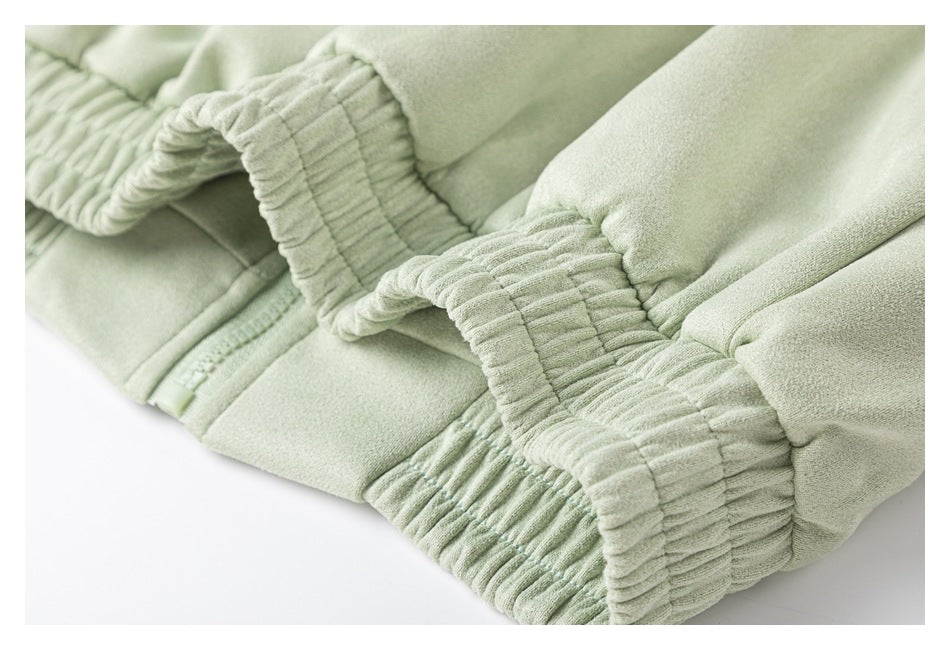 Close-up of gathered elastic cuffs on a pale sage-green garment.