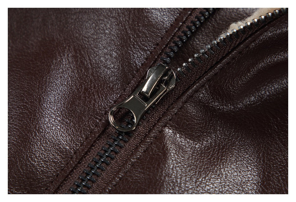 Close-up of a dark metal zipper and pull on the dark brown jacket.