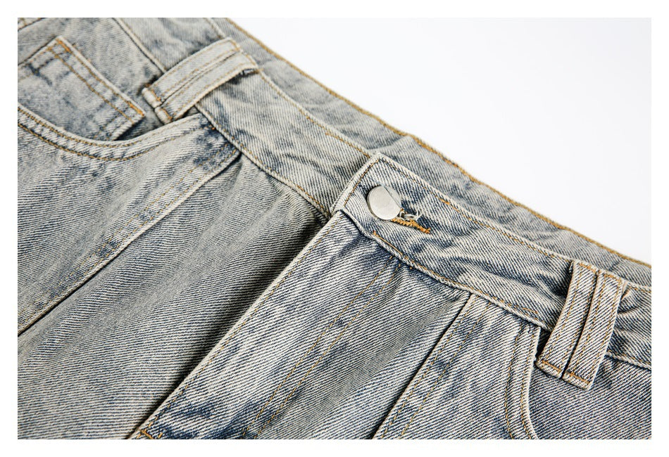 Close-up of the jeans' metal waist button, belt loop, waistband, and faded denim texture.