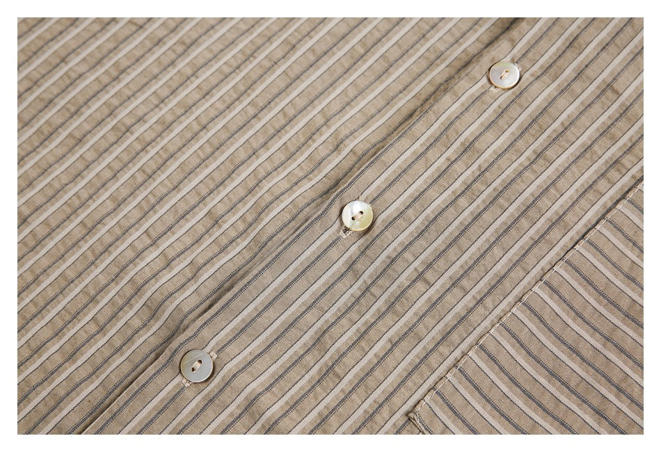 Close-up of the tan shirt's dark pinstripes, button placket, and light buttons.