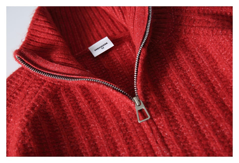 Close-up of a red textured knit garment with a silver zipper and a small white label.