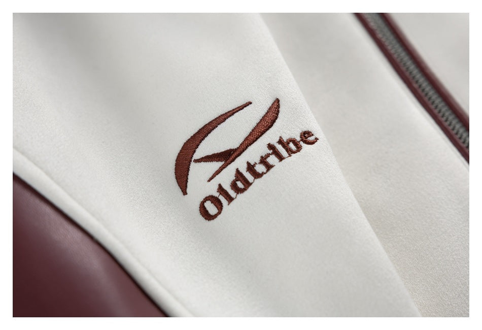 Close-up of burgundy embroidered lettering and a curved emblem on an ivory jacket panel.