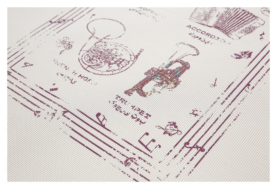 Angled close-up of burgundy vintage-style illustrations and lettering printed on an off-white textured shirt.