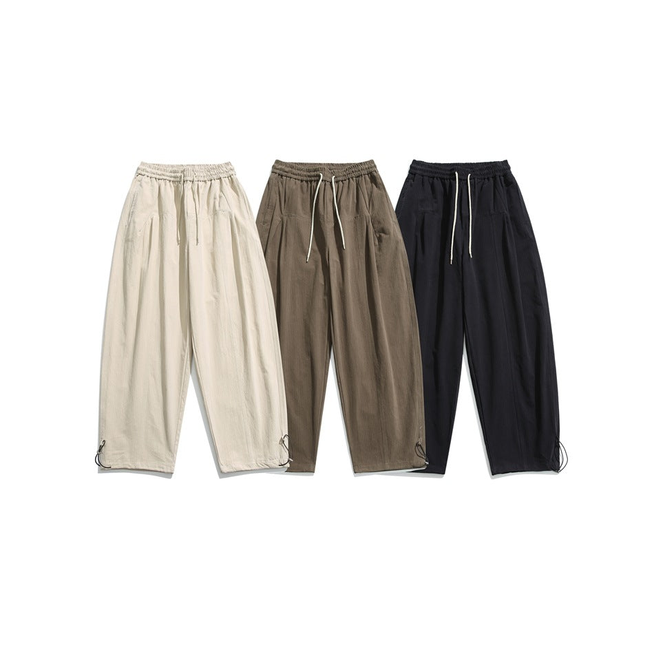 Three pairs of loose drawstring pants displayed in cream, taupe, and black.