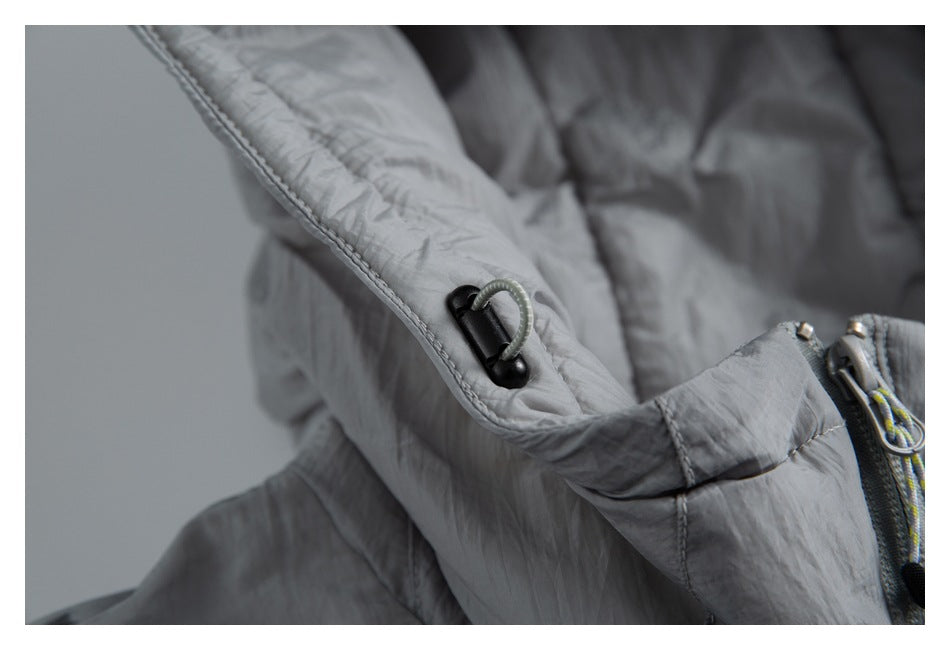 Close-up of a small cord loop and toggle along the edge of the jacket's gray hood.
